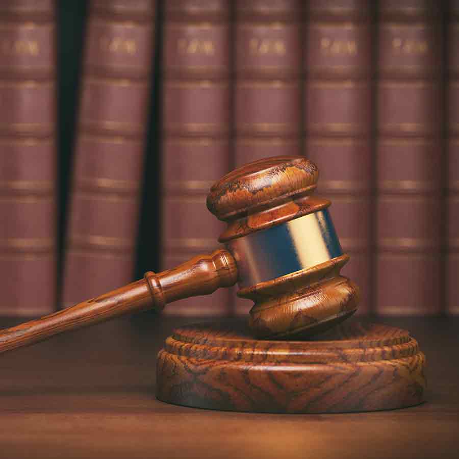 a wooden gavel in front of a row of books