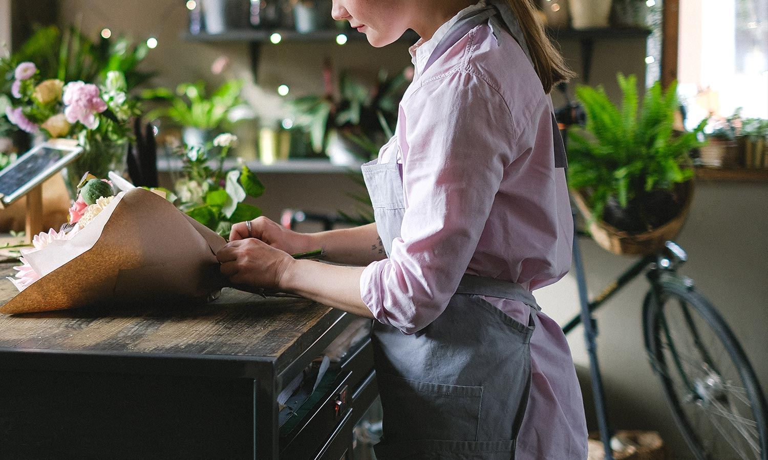 florist wrapping up fresh bouquet in small business