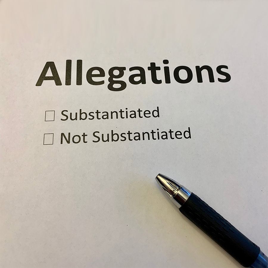 a pen lying on a piece of paper with the words allegations substantiated/not substantiated